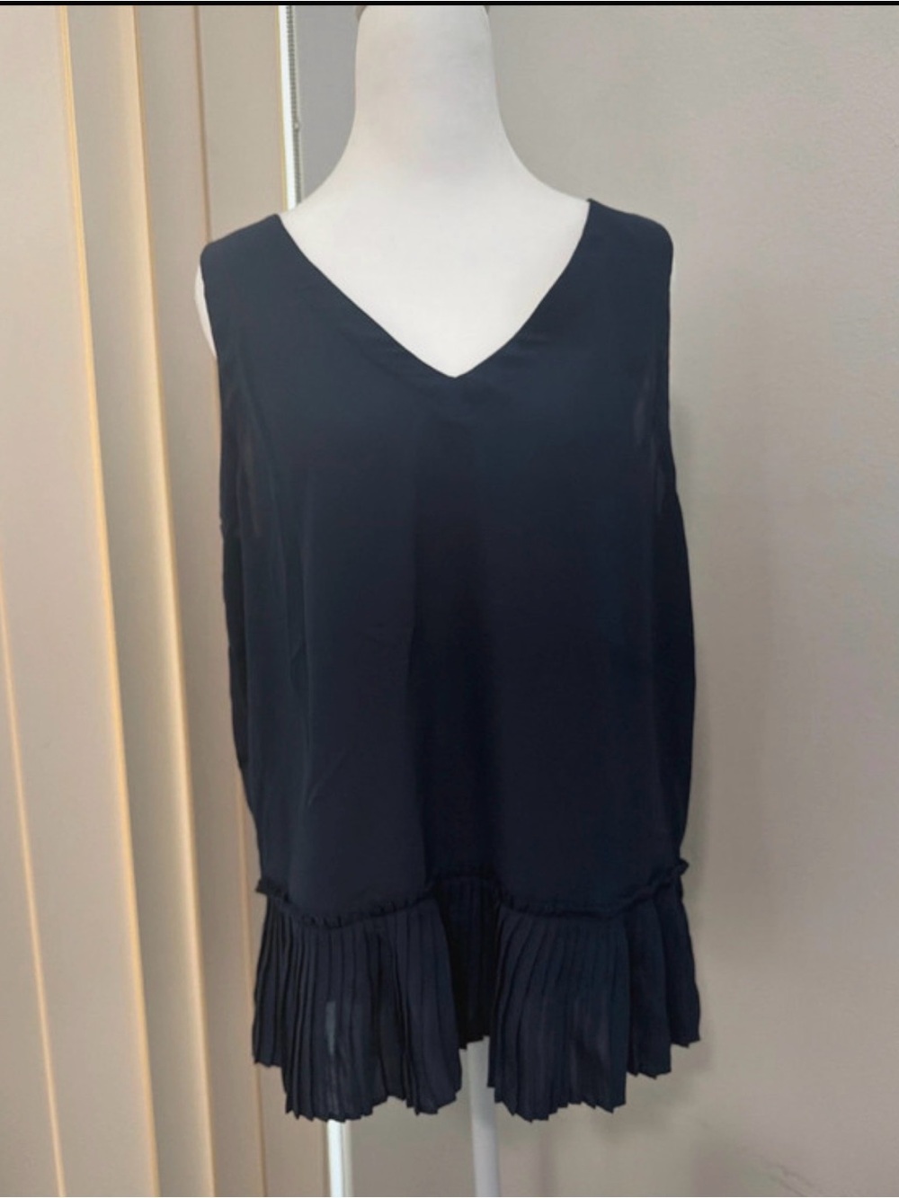 Ariella Navy V‑Neck Sleeveless Pleated Hem Blouse